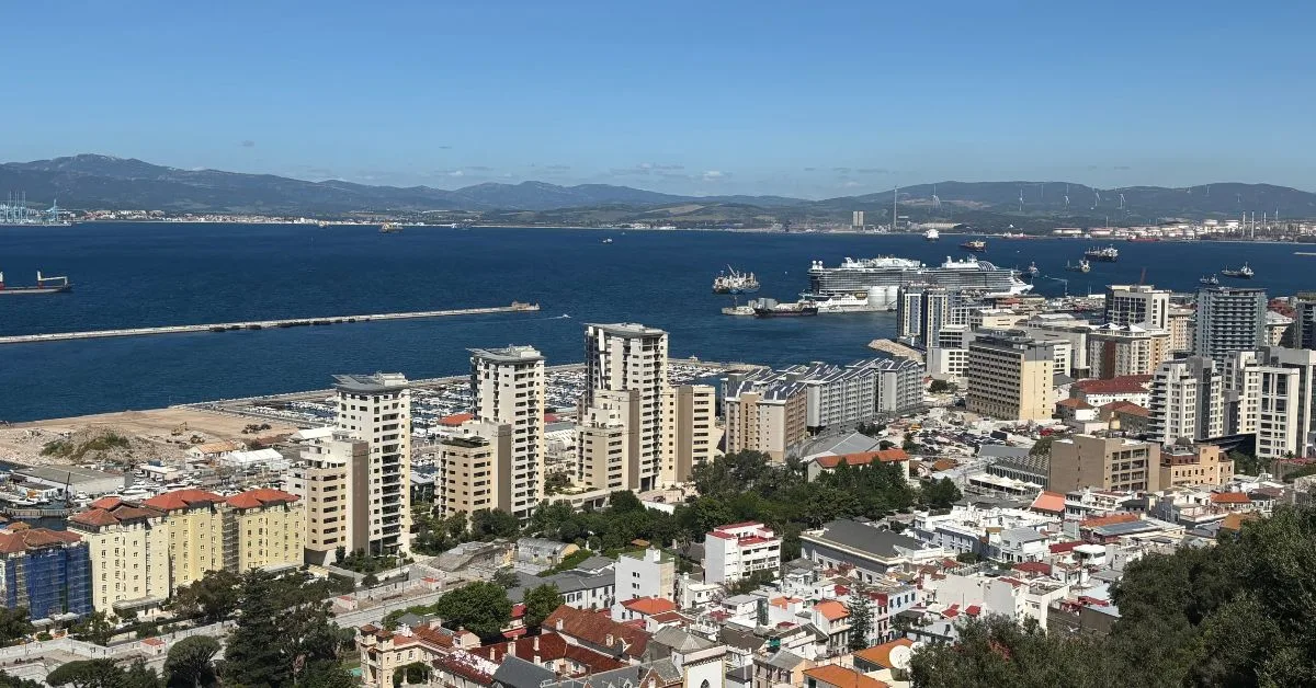 Looking down on Gibraltar town from the Rock with views of Spain in the distance and the Bay of Gibraltar with boats in it