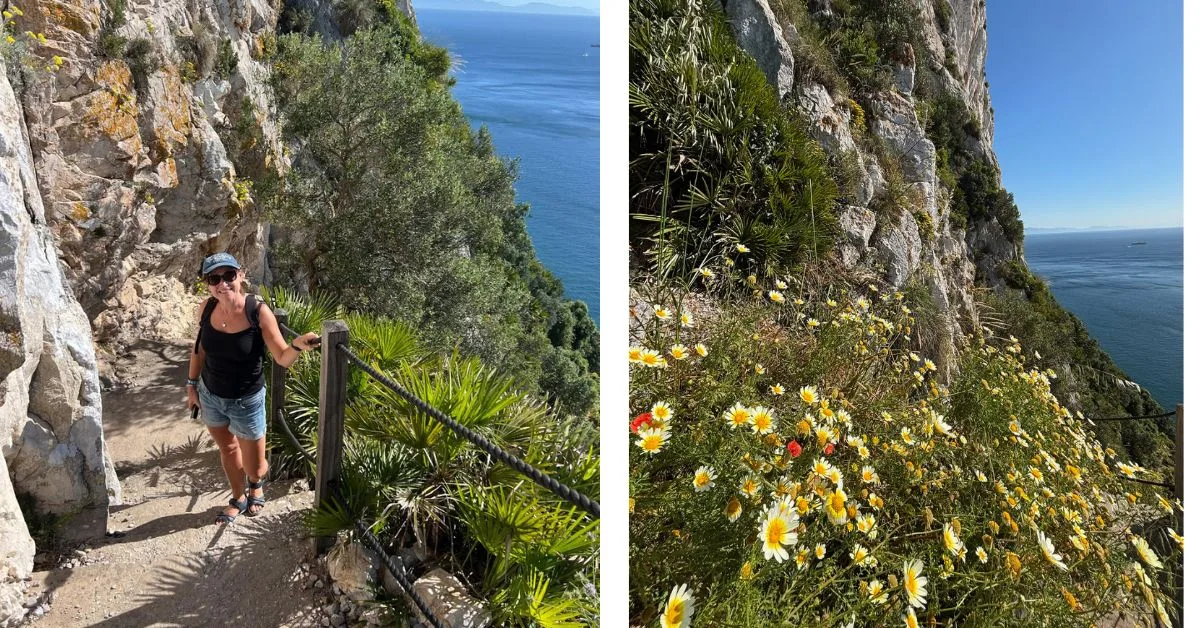 Pathway with roped railing leading up the Rock of Gibraltar with a woman standing on the steps. Pretty wildflowers on the side of the rock