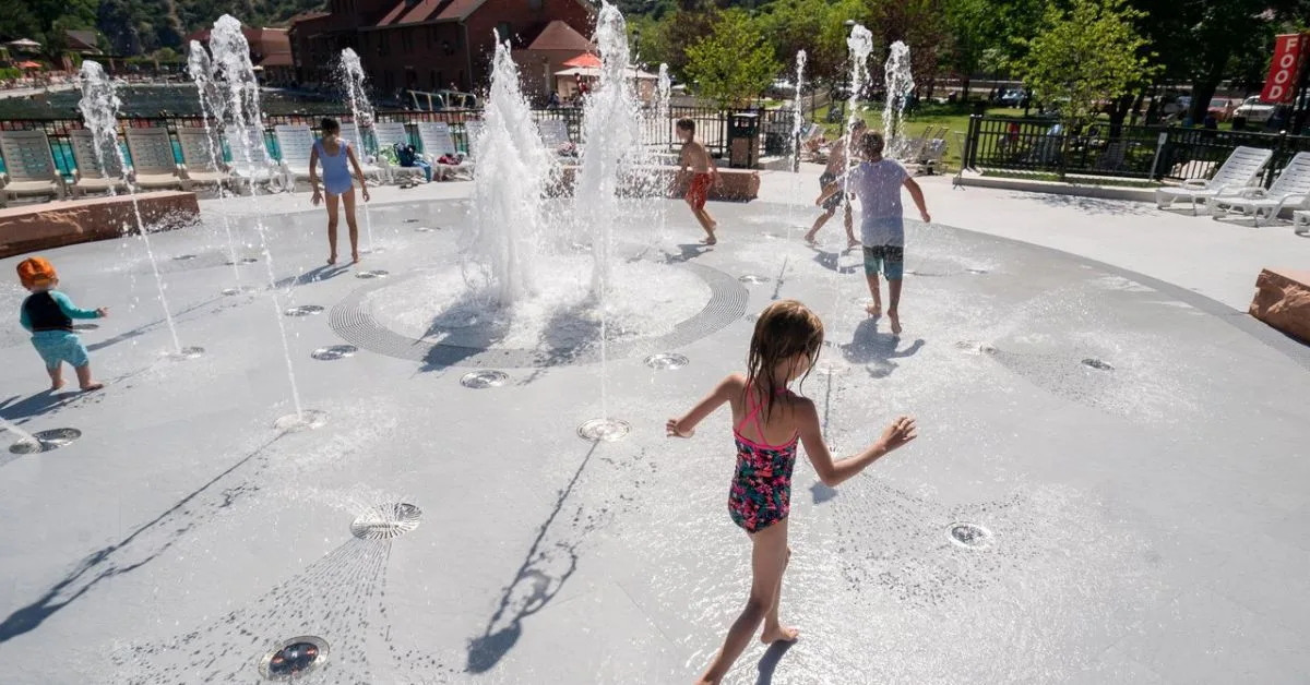 Children running through a splash zone fountains of water at the Hot Springs Resort in .Glenwood Springs