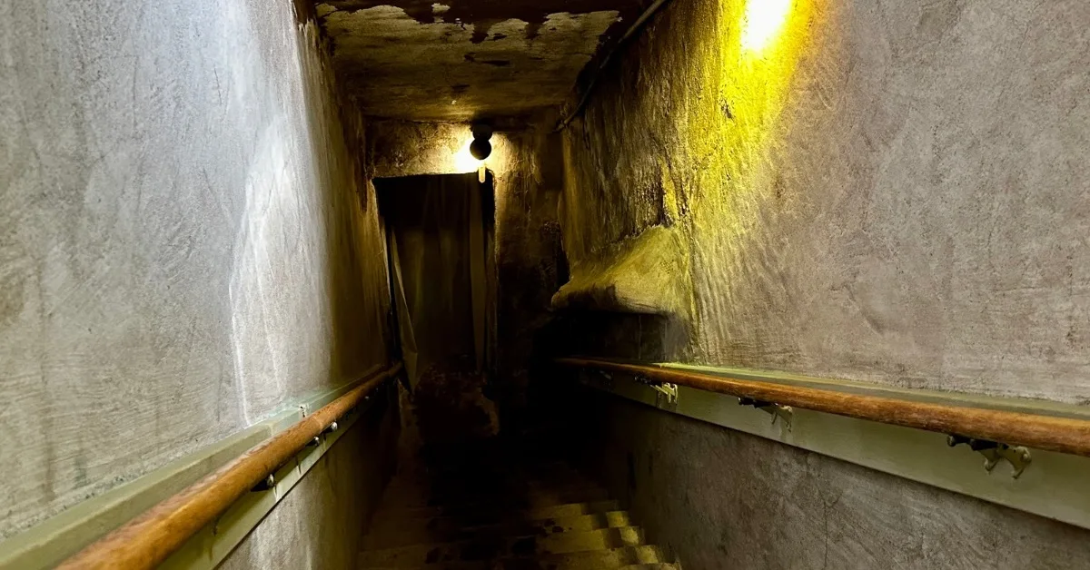 Staircase going down into a vapor steam cave with handrails and lighting to guide visitors.
