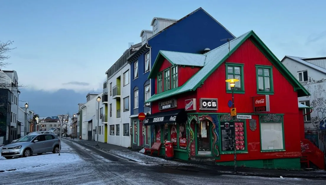 Red, green and blue painted buildings on a snowy city street in Iceland.