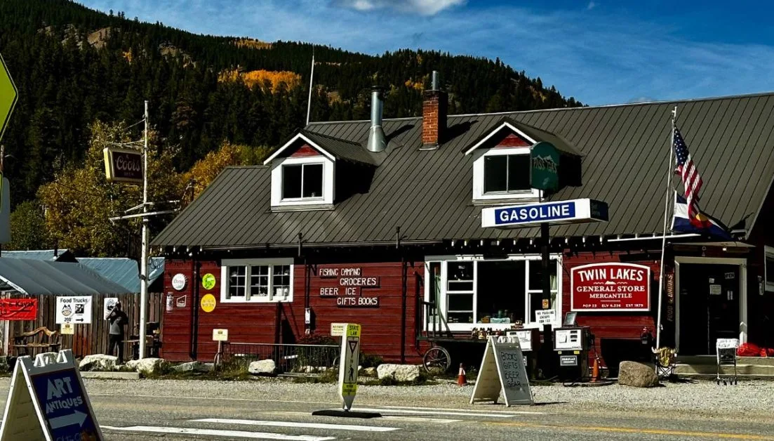 General Store of Twin Lakes with US flag and signs for Gasoline and other items for sale fixed to the front of the brown wooden building.