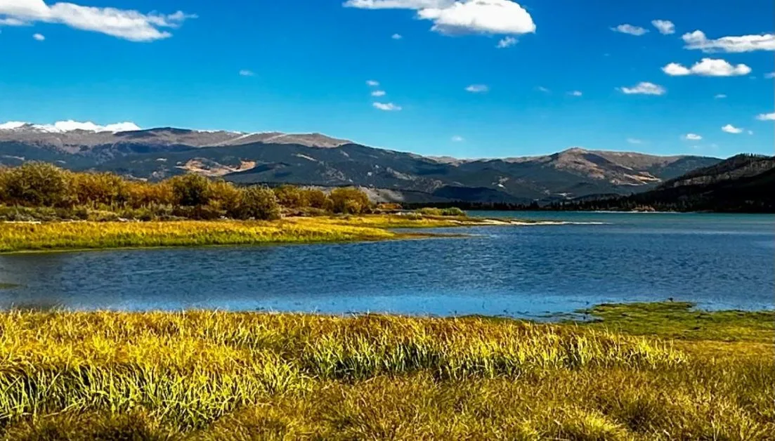 Lake with Rocky Mountains behind it.