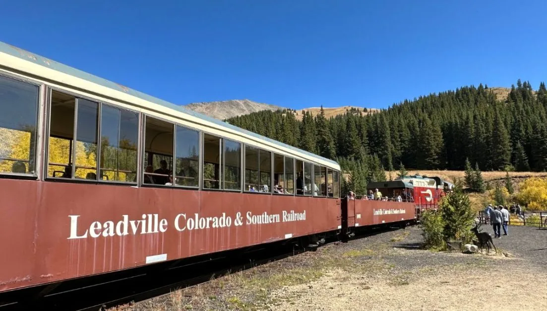 Cars of a tourist train one of the things to do in Leadville, Colorado. Passengers are enjoying a stop during a mountain trail route.
