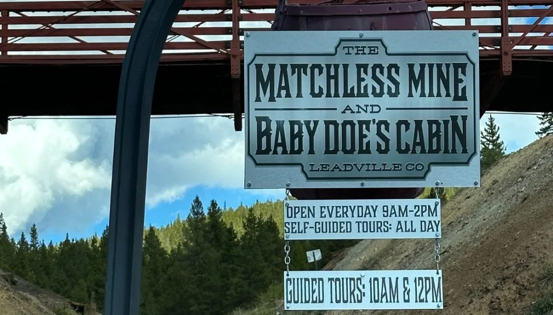 Sign to Matchless Mine showing opening hours for visitors.
