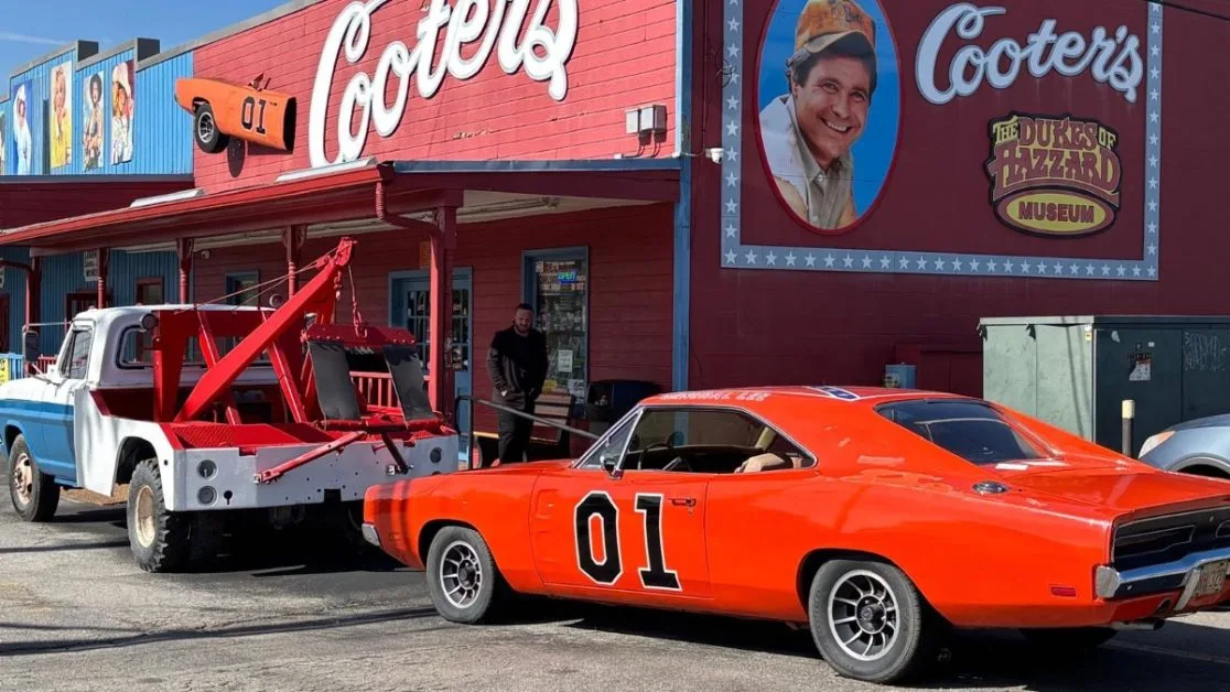 A Red sports car and tow truck advertising the Dukes of Hazzard Museum.