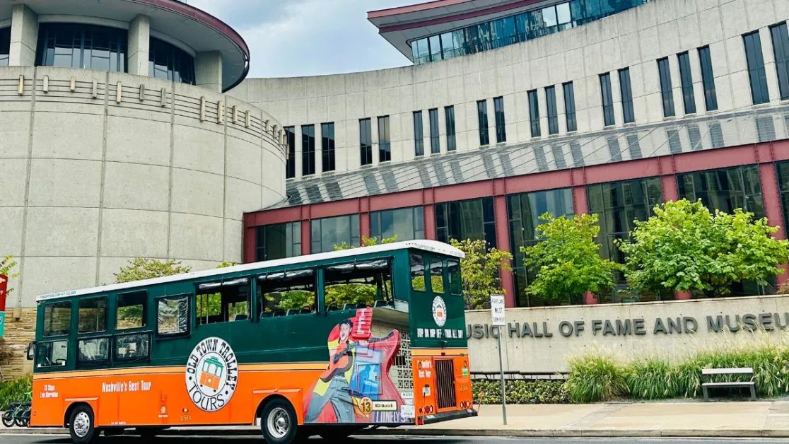Orange and Green Old Town Trolley bus outside the Country Music Hall of Fame in Nashville.