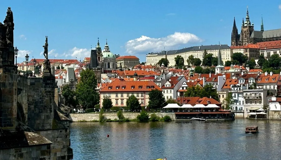 View of Old Town Prague and its river. Red roof buildings fill the town.