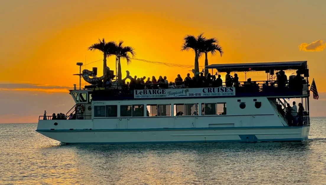 Things to Do in Sarasota always involves a sunset. This is a daily cruise at sunset. The photo shows people watching the sunset from a open top deck.