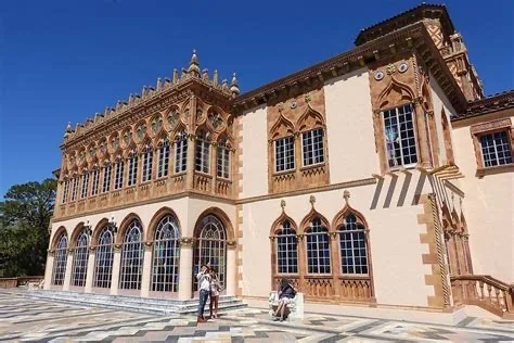 One of the most historic things to do in Sarasota is visit the Ringling Museum. People are admiring the Venetian style home and patio.
