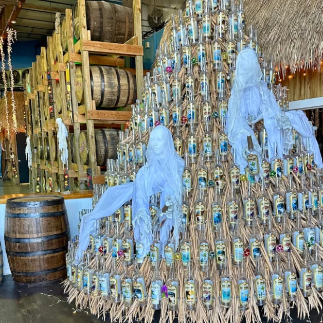A fun Sarasota activity is to go rum tasting. This festive display is made of old rum bottles and behind the display are barrels of aging rums.