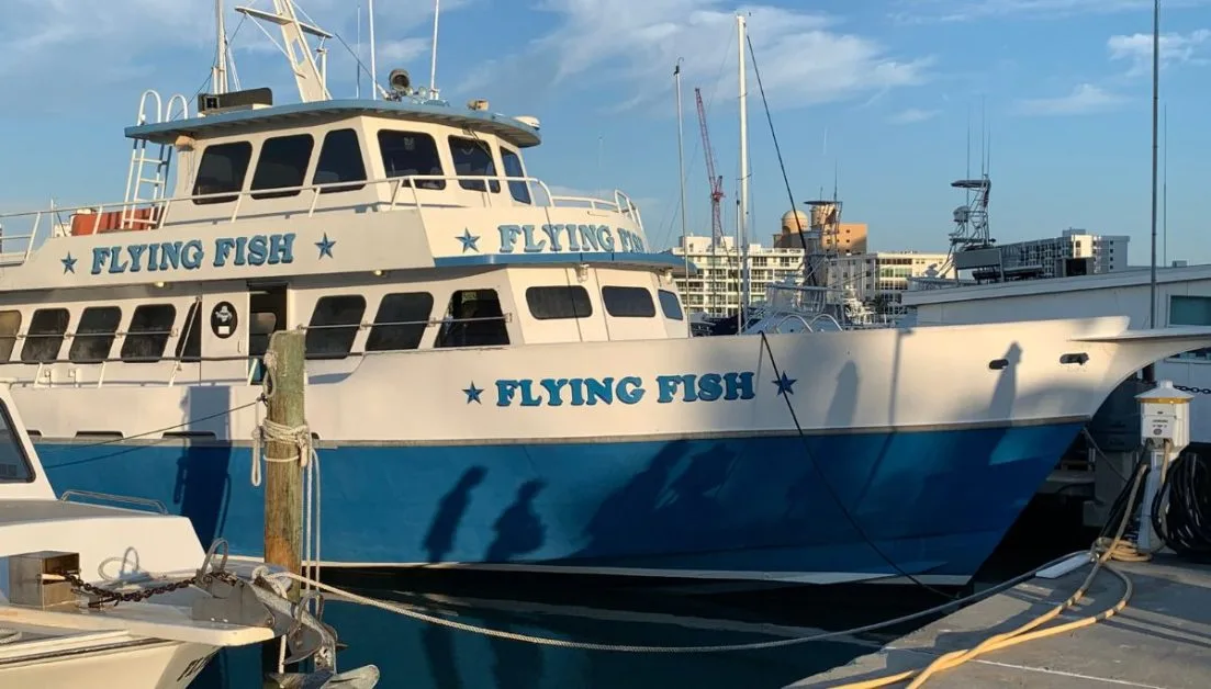 A blue and white fishing boat called 'Flying Fish' that leaves daily from Sarasota Marina. Fishing is one of the most loved Sarasota activities for visitors.