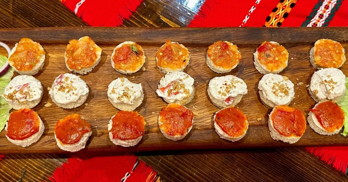 Bulgaria appetizer made from bread, garlic, yoghurt and peppers some of their traditional foods. Cut into small rounds these toppings are on freshly made bread.