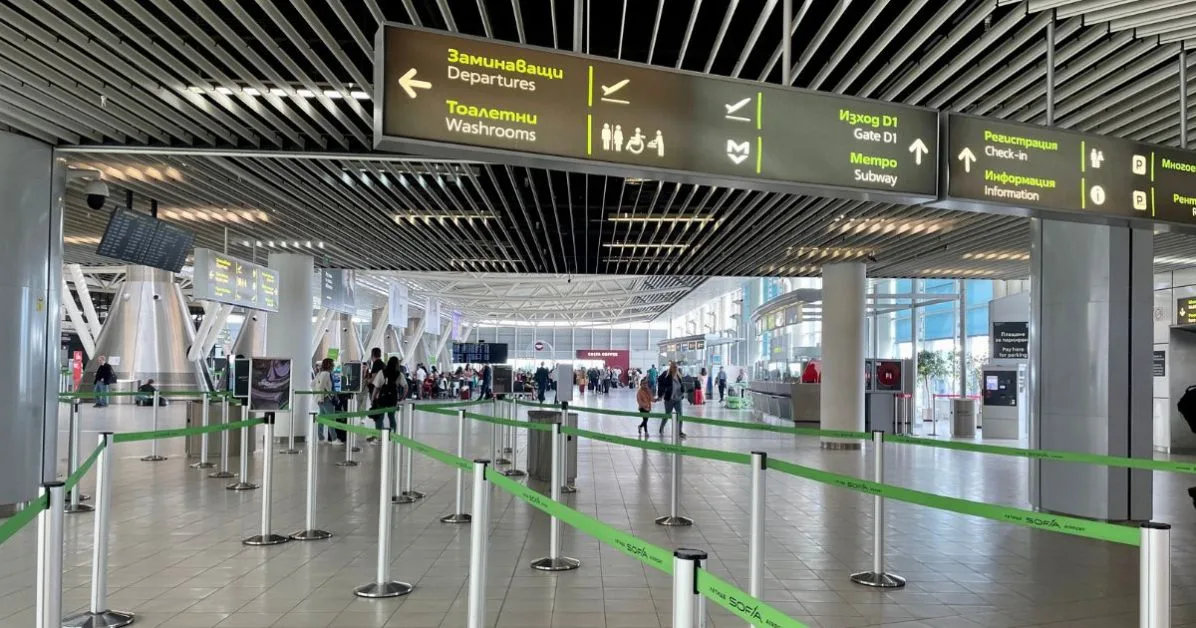 Sofia Airport arrivals hall with signs for metro and other facilities.