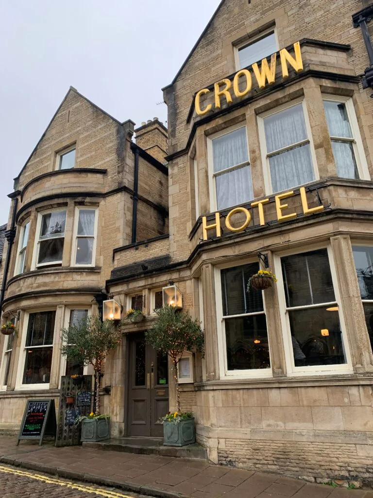 Exterior stone building with bay windows is a Crown Hotel in Stamford UK.
