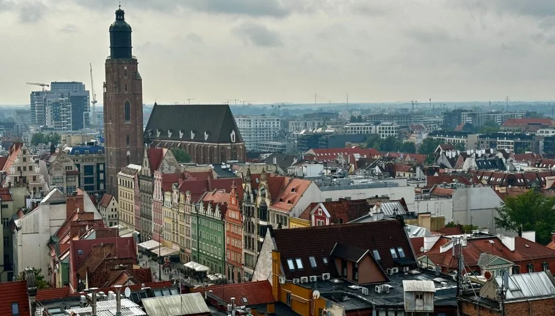 Rooftops of Wroclaw with steeples, towers and red roofed buildings. The square has multicolored buildings from green to orange and spending time in it is one of the best things to do in Wroclaw.