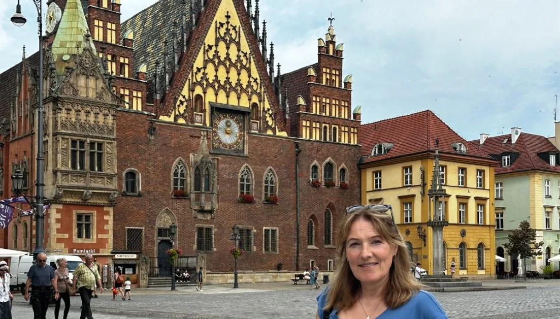 Woman standing in front of the Gothic town hall in Wroclaw.