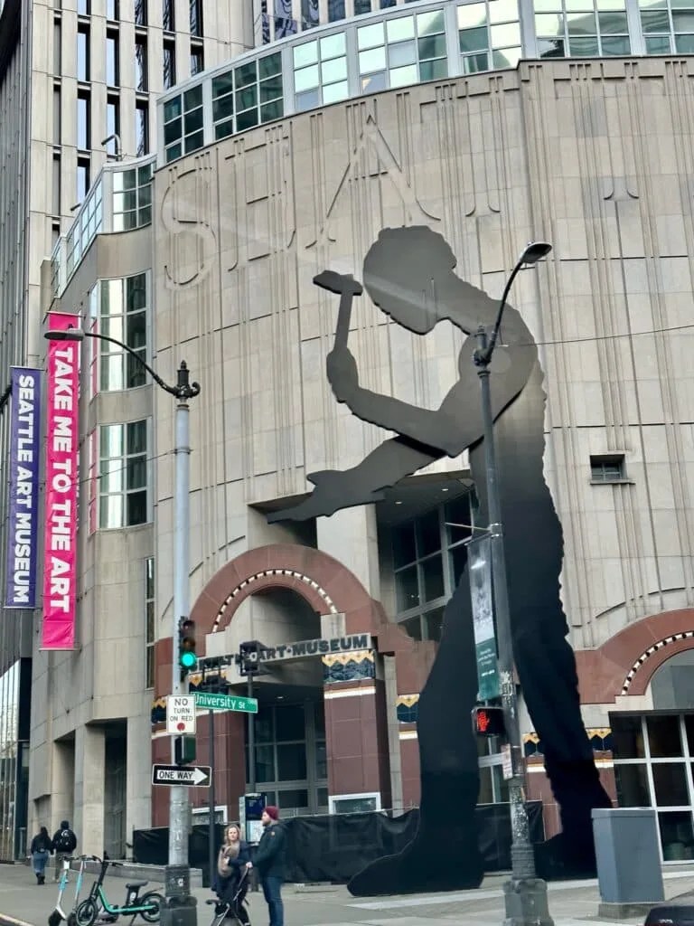 The outside of a museum in Seattle shows a worker with a hammer.