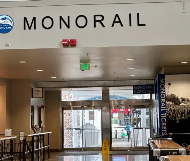 A monorail station in Seattle with entrance and exit signs for passengers.