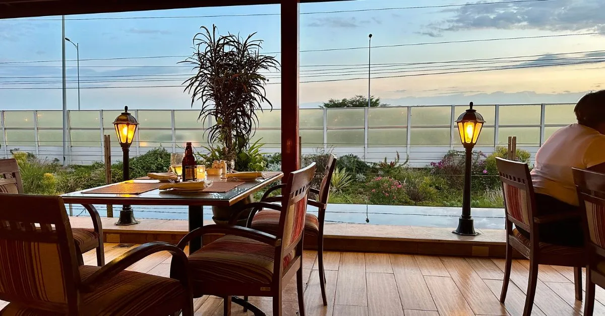 View of Nairobi National Park from Ole Sereni Hotel Restaurant where tables and chairs are set out for dinner.