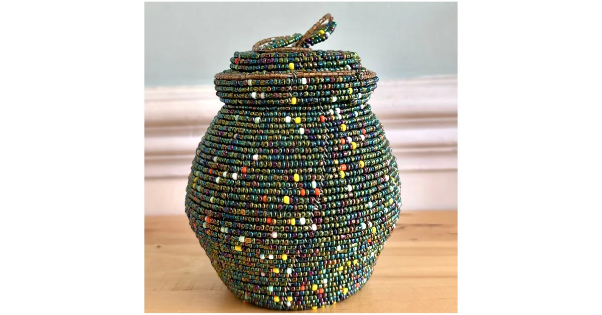 A small multi colored beaded storage jar made by Masai Mara craftspeople.