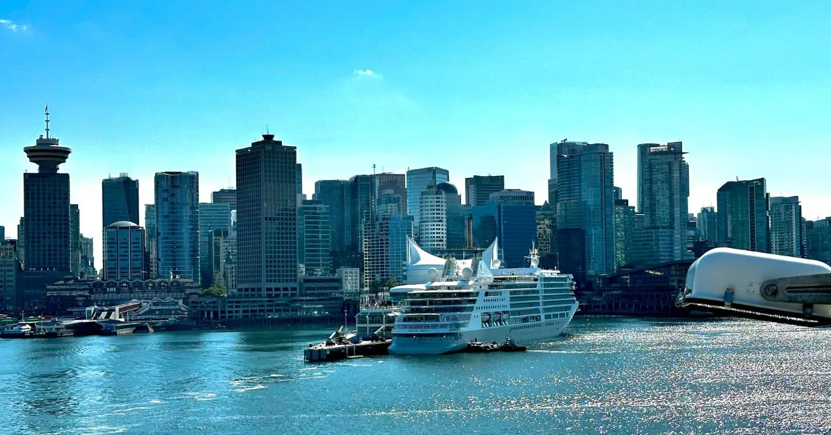 Tall skyscrapers frame the skyline behind Canada Place Harbour where a cruise ship is docked.