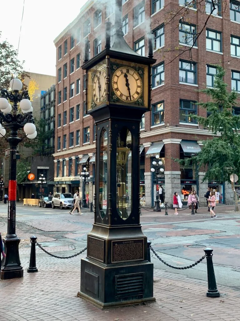 Iconic steam clock in Vancouver with a black steel case and traditional clock face. It puffs steam.