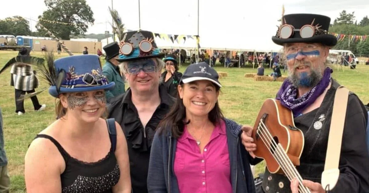 Two couples enjoying Woodbridge Folk Festival. One has a small musical instrument like a guitar.