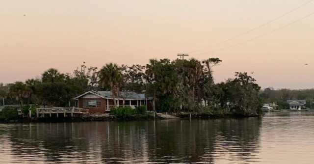 Sunrise and a view from the water as we left Pete Pier. There is a light pink reflection from the sky on the water.