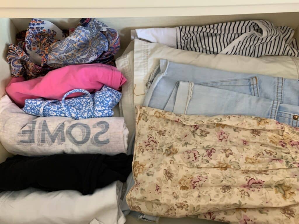 Photo shows clothes rolled to fit into hand luggage on a plane.