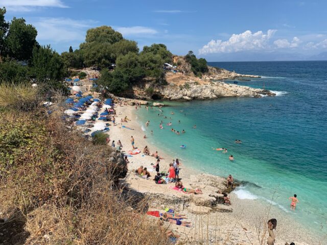 A beach leading to turquoise waters in Corfu