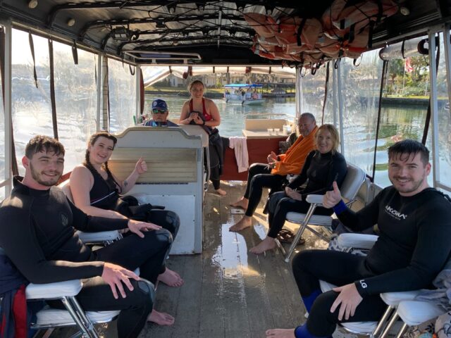 Tourists are on board a small boat that is searching on Crystal River Florida for Manatees.