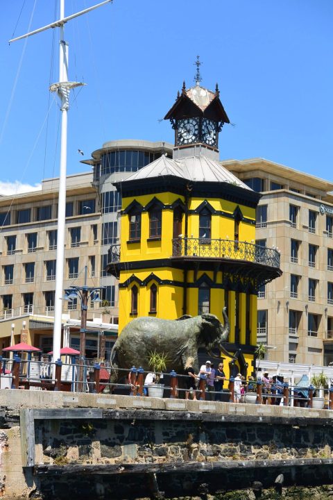 A clock tower painted yellow at the main harbour in Cape Town.