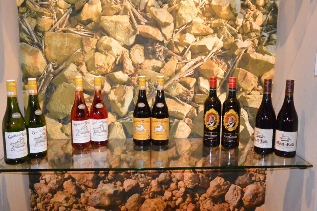 A shelf showcasing a range of wines made at Goats Do Roam winery.
