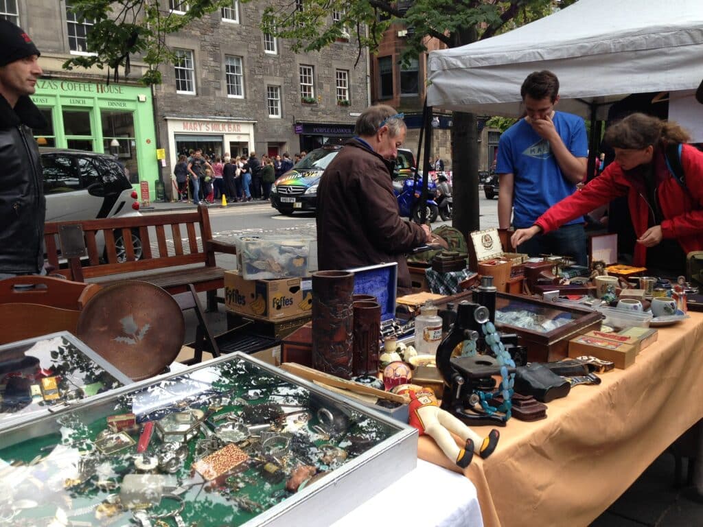 Stalls are selling antiques and crafts in an open air market in Edinburgh, Scotland