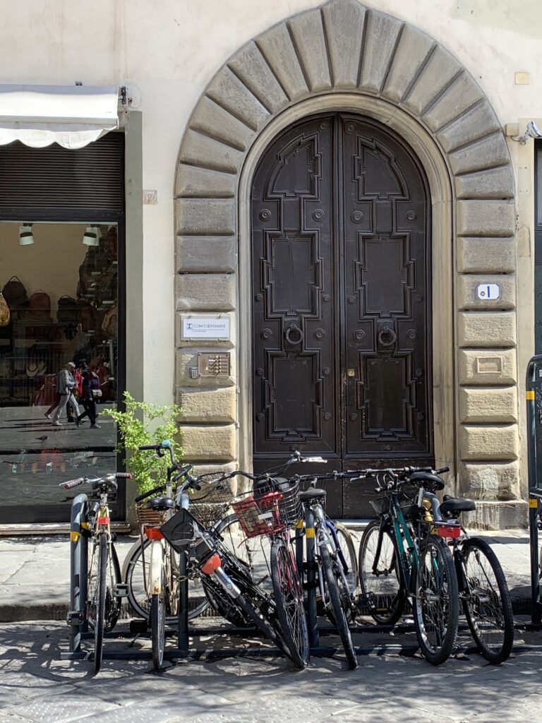 Bikes sit parked outside a brick arch doorway.