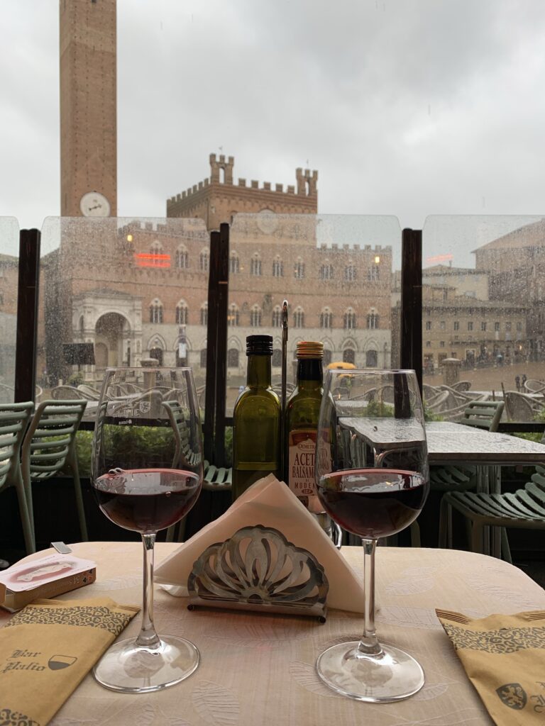 Wine and glasses at a rooftop cafe in Siena Italy.