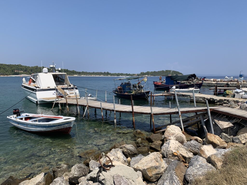 A small jetty juts out from a rocky shore.