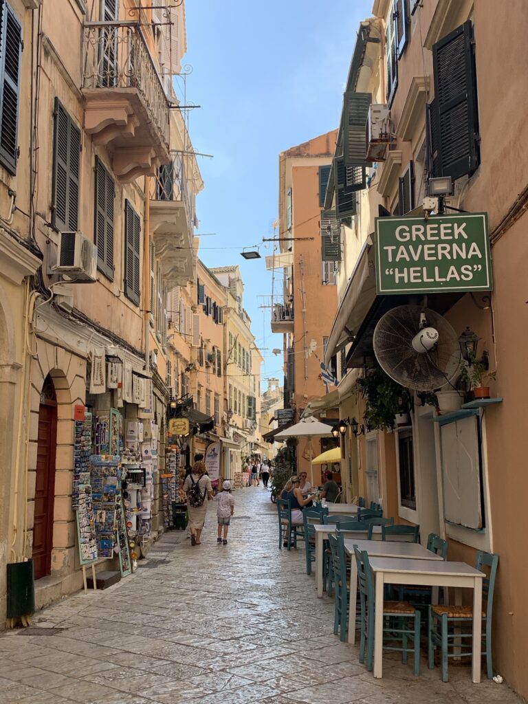 Street in Corfu Town with tables and tavernas for tourists.