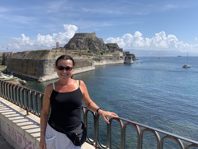 Woman standing over a bridge over water.