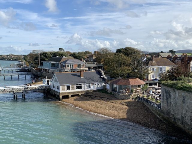 Coastal scene of houses which have long wooden docks out over the water.