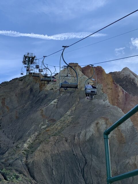 Several cable cars are in view transporting visitors to the top of what is called 'The Needles' geological form in southern England.