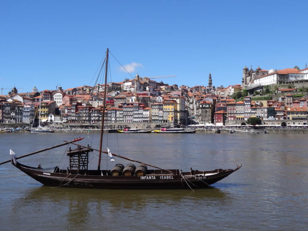 A boat in Porto harbour with the town in the background.