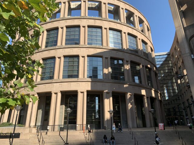 Downtown building in Vancouver, Canada with curved design, 4 levels and uniform windows.
