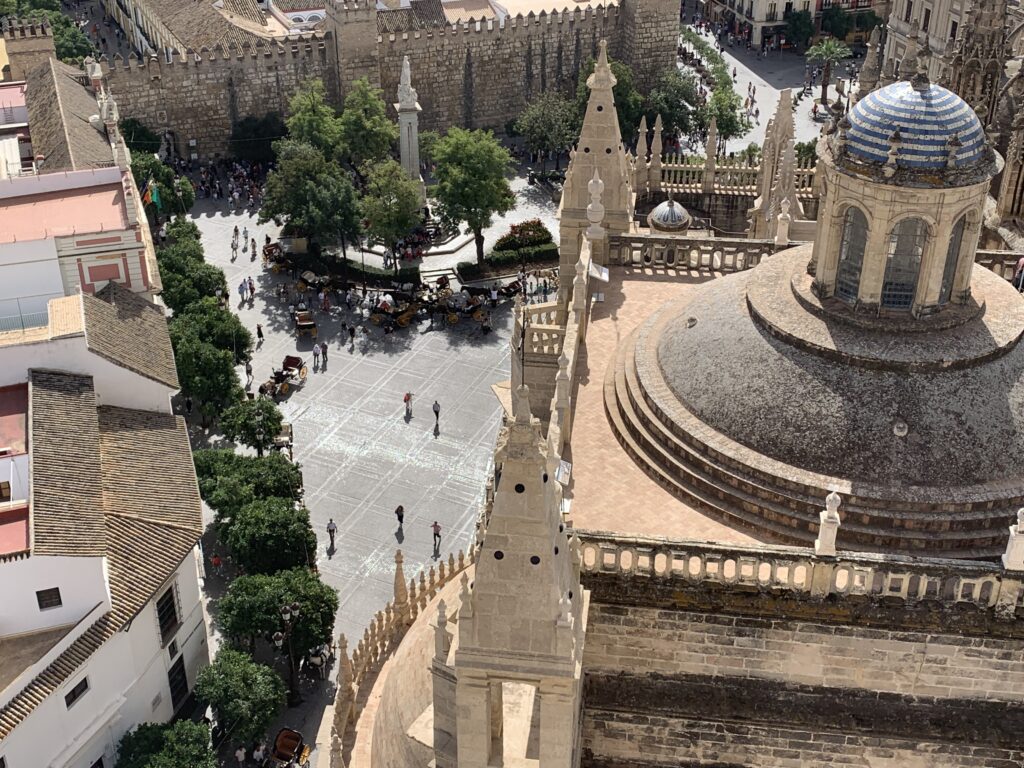 Sitting at a rooftop bar in Seville there are views over rooftops, palace domes and streets.