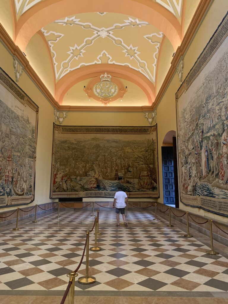 A room within a palace showing wall tapestries.