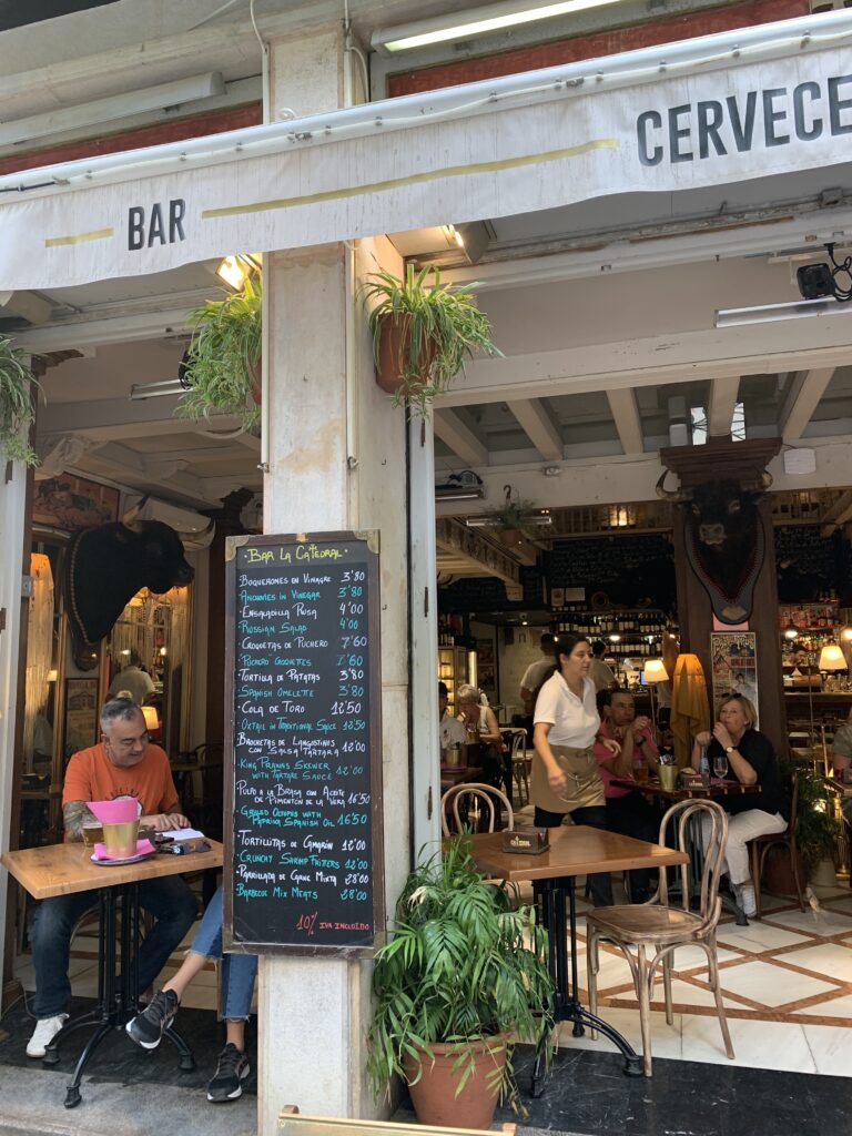 Outdoor seating and open access to the main restaurant. A black board advertise the daily menu.