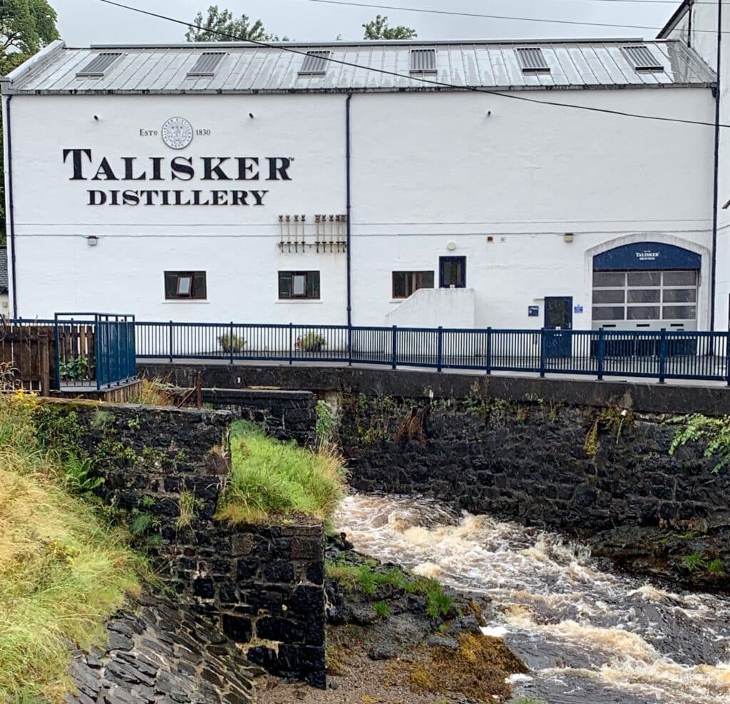 The outside of a storage building at a Talisker distillery on Isle of Skye Scotland. A river runs next to the distillery, used for production of the drink.