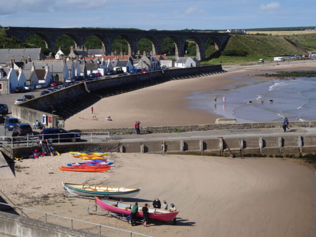 Kayaks and small boats line on the beach at a small fishing village.