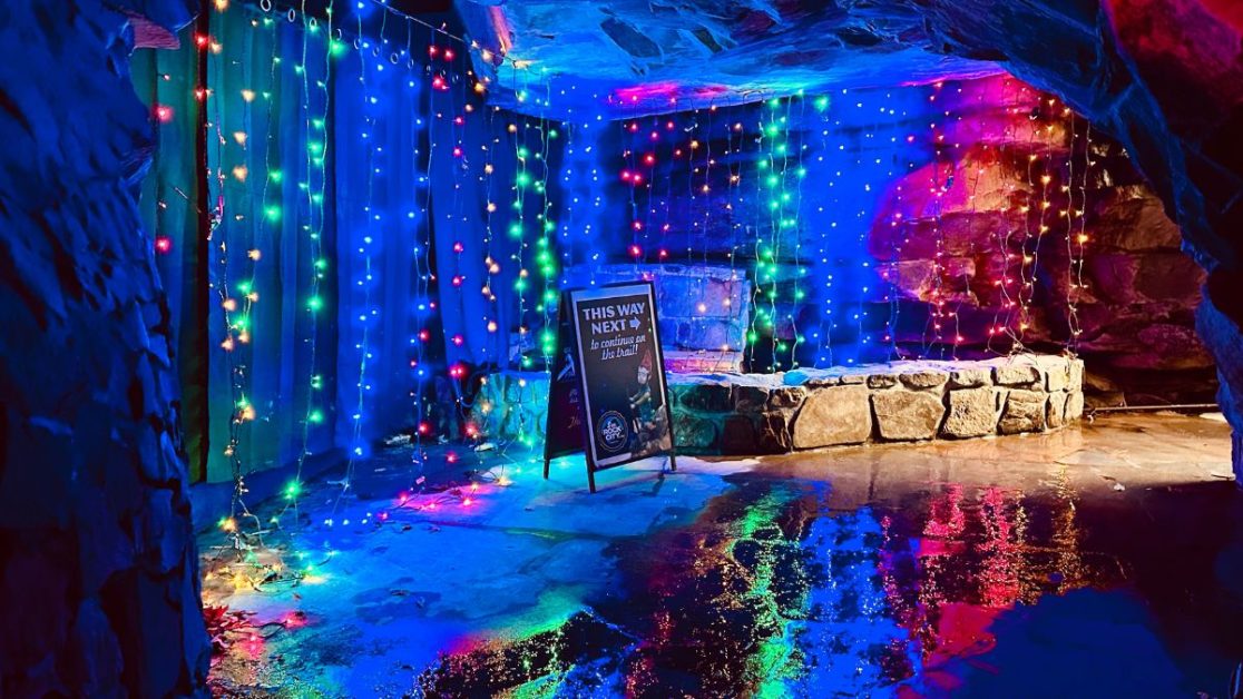 Lights of different colors hanging inside a cave.